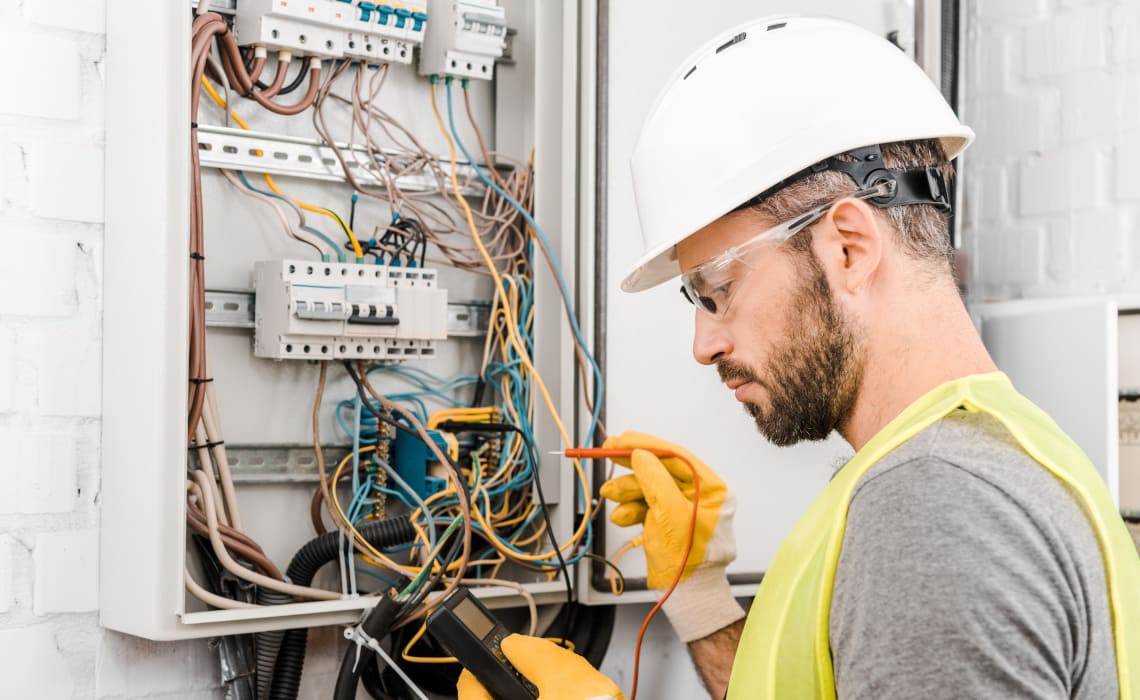 Elektriker prüft Elektroinstallation im Sicherungskasten mit Messgerät