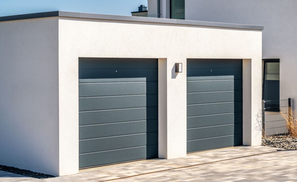 Moderne Garagenbox mit zwei Sektionaltoren bei Einfamilienhaus
