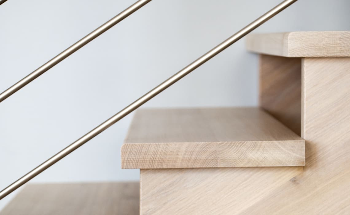 Neue Treppe - Moderne Holztreppe mit klaren Stufen und filigranem Metallgeländer im Innenbereich