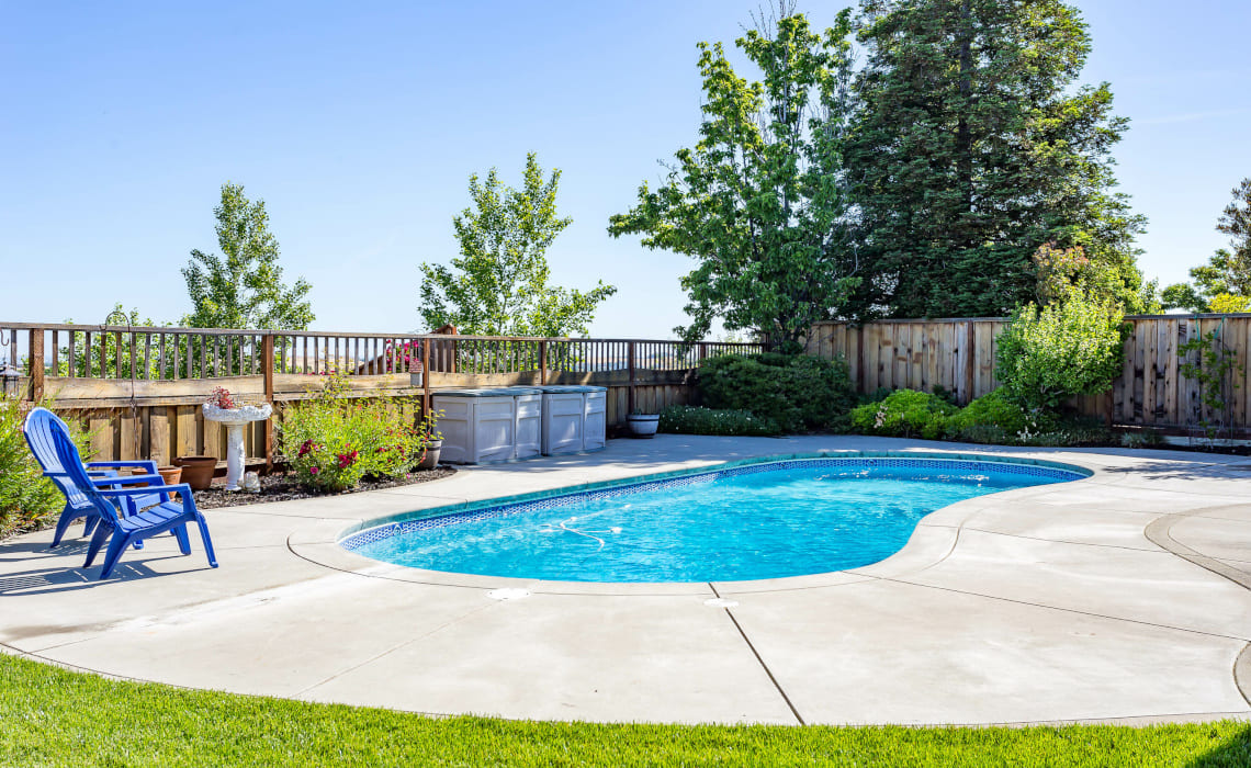 Pool bauen - Moderner Gartenpool mit Betonumrandung im Einfamilienhausgarten in der Schweiz